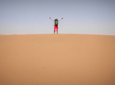 Sırt çantalı bir kadın çölde yürüyüş yapıyor. 