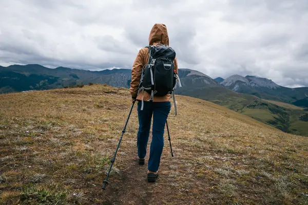 Sırt çantalı bir kadın yüksek irtifada dağ yürüyüşü yapıyor. 