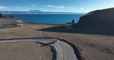 Sahilde hareket eden bir arabanın havadan görüntüsü.  