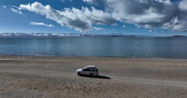 Sahilde hareket eden bir arabanın havadan görüntüsü.  