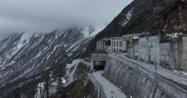 Yüksek irtifada, karla kaplı dağlarda ve orman manzarasında yol görüntüleri.