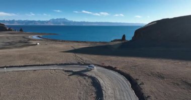 Sahilde hareket eden bir arabanın havadan görüntüsü. 