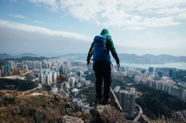 Kadın yürüyüşçü dağın tepesinde duruyor Hong Kong ve Shenzhen Ctiy 'in güzel manzarasına bakıyor.
