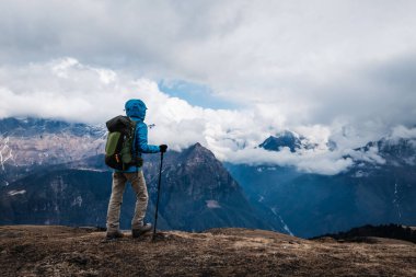 Sırt çantalı bir kadın yüksek irtifada dağ yürüyüşü yapıyor.