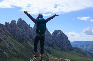 Sırt çantalı bir kadın yüksek irtifada dağ yürüyüşü yapıyor. 