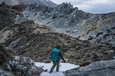 Sırt çantası Tibet 'te dağın tepesine tırmanıyor