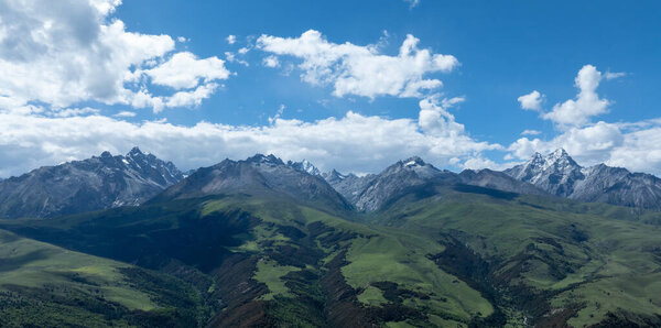 Вид с воздуха на красивые высокогорные снежные шапки и ландшафт лесных лугов в Китае