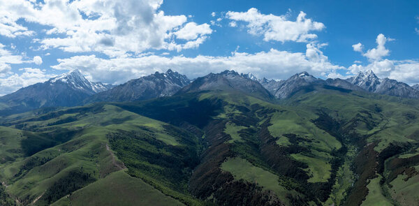Вид с воздуха на красивые высокогорные снежные шапки и ландшафт лесных лугов в Китае