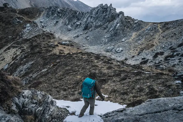Sırt çantası Tibet 'te dağın tepesine tırmanıyor