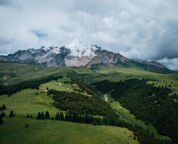 Вид с воздуха на красивые высокогорные снежные шапки и ландшафт лесных лугов в Китае