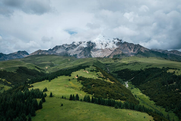 Вид с воздуха на красивые высокогорные снежные шапки и ландшафт лесных лугов в Китае