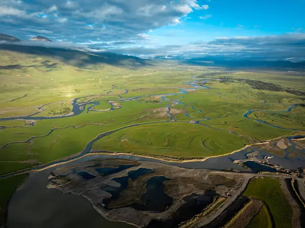 Dalgalı nehirleri olan canlı yeşil bir vadinin çarpıcı hava manzarası..