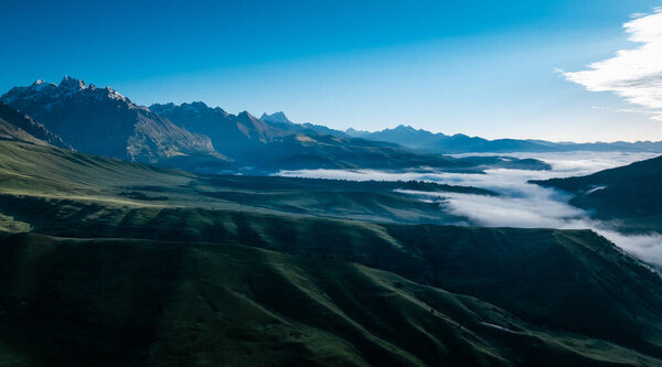 Вид с воздуха на красивые высокогорные снежные шапки и ландшафт лесных лугов в Китае