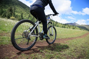 Asfalt yolda görkemli dağlarda bisiklet süren sportif ve aktif bir motorcunun görüntüsü. 