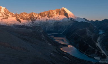 stunning sunrise glows over the vast, snow-covered mountains with lakes 