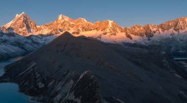 stunning sunrise glows over the vast, snow-covered mountains with lakes 