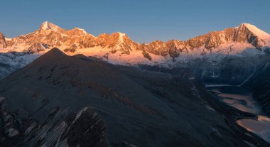 stunning sunrise glows over the vast, snow-covered mountains with lakes 