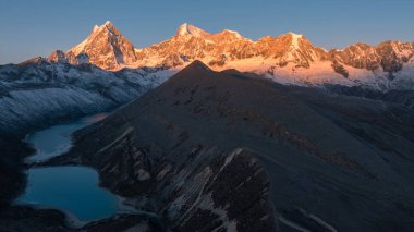 stunning sunrise glows over the vast, snow-covered mountains with lakes 