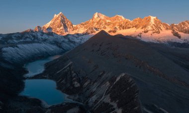 stunning sunrise glows over the vast, snow-covered mountains with lakes 