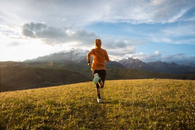 aktif, dişi koşucu dağ manzarasında koşuyor 