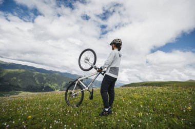 Otlağın tepesinde dağ bisikleti sürüyorum