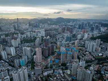 6 Temmuz 2022, Shenzhen City, Çin 'deki hava manzarası. Çok sayıda yüksek bina ve dağlarla dolu yoğun bir şehir manzarasının fotoğrafı.
