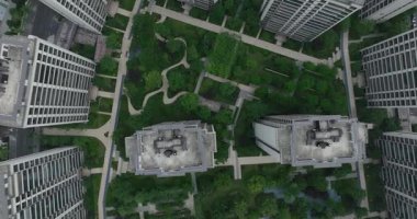 Yeşil alan ve dolambaçlı yollarla çevrili modern yerleşim yerlerinin yukarıdan aşağıya görüntüsü.