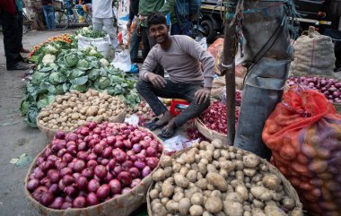 Bir pazarda sebze satan tedarikçi, 1 Şubat 2024 'te Hindistan' ın Guwahati kentinde, Birlik Maliye Bakanı Nirmala Sitharaman tarafından yapılan Geçici Bütçe 2024 'ün sunumu öncesinde, 1 Şubat 2024' te. 