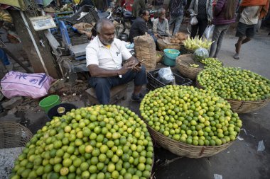 Bir pazarda limon satan tedarikçi, Birlik Maliye Bakanı Nirmala Sitharaman 'ın 1 Şubat 2024' te Hindistan 'ın Guwahati kentinde sunumu öncesinde, 1 Şubat 2024' te. 
