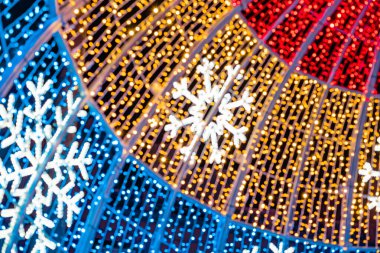 Soyut ışıklar. Noel sokak dekorasyon ışıkları, odak dışı, daireler şeklinde. Mavi, altın ve kırmızı ışıklar, siyah arkaplan. Tenerife, Kanarya Adaları, İspanya.