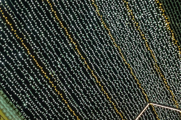 Soyut ışıklar. Altın ve yeşil ışıklar, odak dışı, siyah arka planlı Noel ışıkları. Tenerife, Kanarya Adaları, İspanya.