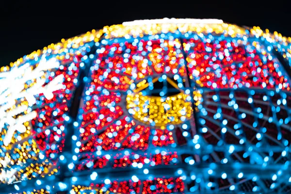 Abstract lights. Christmas street decoration lights, sphere-shaped, out of focus, gold, red, blue and white colors, with black background. Tenerife, Canary Islands, Spain.