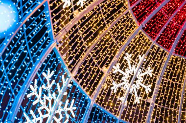 Soyut ışıklar. Noel sokak dekorasyon ışıkları, odak dışı, daireler şeklinde. Mavi, altın ve kırmızı ışıklar, siyah arkaplan. Tenerife, Kanarya Adaları, İspanya.