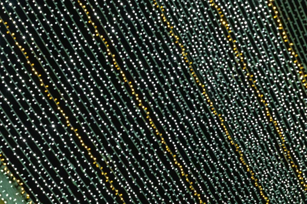 Soyut ışıklar. Altın ve yeşil ışıklar, odak dışı, siyah arka planlı Noel ışıkları. Tenerife, Kanarya Adaları, İspanya.