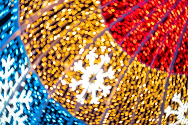 Abstract lights. Christmas street decoration lights, out of focus, in the shape of circles.  Blue, gold and red lights, with black background. Tenerife, Canary Islands, Spain.