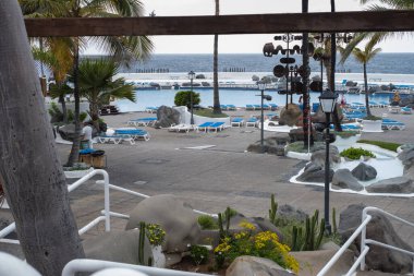 Lago Martianez 'in havuzlarının manzarası. Mavi hamaklar, doğal havuzlar, bitkiler ve şemsiyeler. Puerto de la Cruz, Tenerife, Kanarya Adaları, İspanya.