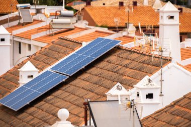 Tek aile evlerinin çatısında bir grup güneş paneli. Güneş panelleri. Temiz enerji. Ekoloji. Kırmızı kiremitler. Tenerife, Kanarya Adaları, İspanya