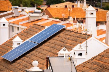 Tek aile evlerinin çatısında bir grup güneş paneli. Güneş panelleri. Temiz enerji. Ekoloji. Kırmızı kiremitler. Tenerife, Kanarya Adaları, İspanya