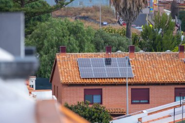 Kırmızı tuğlaları ve kırmızı fayansları olan tek bir aile evinin çatısındaki güneş panelleri. Tenerife, Kanarya Adaları, İspanya