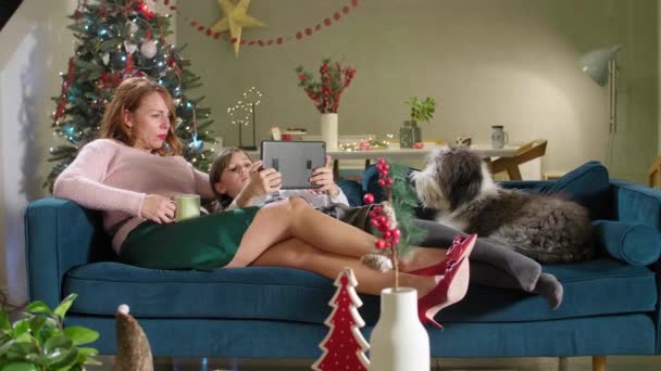 Мама Сидить Дивані Своєю Донькою Собакою Кімната Прикрашена Духом Різдва — стокове відео