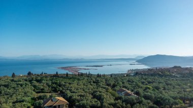 Yunanistan 'ın Lefkada adasındaki Agios Ioannis plajının hava manzarası. Önünde zeytin ağaçları ve uzakta da anakara var..