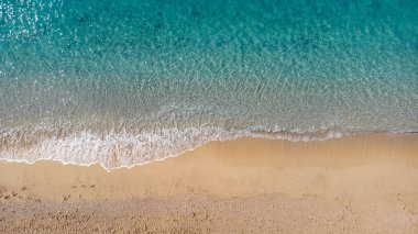 Güzel kumlu sahil manzarası ve yumuşak turkuaz okyanus dalgası. Yaz mevsiminde Lefkada adasındaki Egremni sahilinde tropikal deniz..