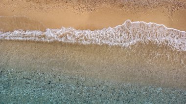 Güzel kumlu sahil manzarası ve yumuşak turkuaz okyanus dalgası. Yaz mevsiminde Lefkada adasındaki Egremni sahilinde tropikal deniz..