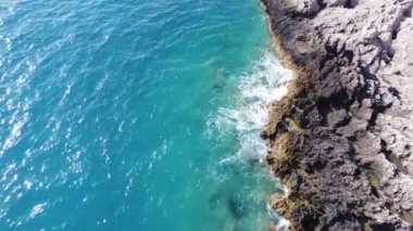 Porto Katsiki sahilindeki kayalara çarpan deniz manzarası. Lefkada adasında yaz mevsiminde tropik turkuaz deniz.