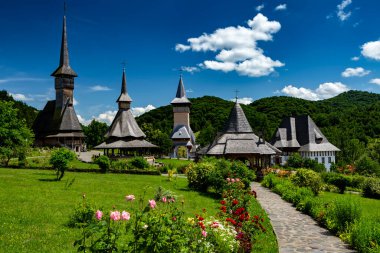 Barsana ahşap kilise (solda) ve Barsana, Maramures, Romanya 'da romantik gökyüzü bulunan manastır kompleksi.