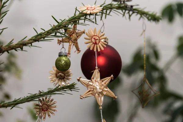 stock image Straw stars and Christmas tree balls on the Christmas tree - decorative tree hangings