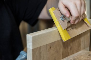 Sanding wood with sandpaper on the sanding block as a tool clipart