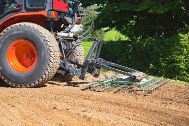 Harrow 'lu küçük traktör toprağı gevşetiyor - bahçe tasarımı