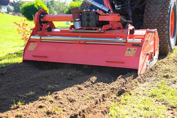 stock image Soil cultivation with a tiller and small tractor - garden landscaping with a reversible tiller