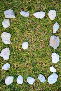 Yeşil çayırdaki doğal taşlardan yapılmış dikdörtgen bir taş yumurta - arka plan ve kopyalama alanı